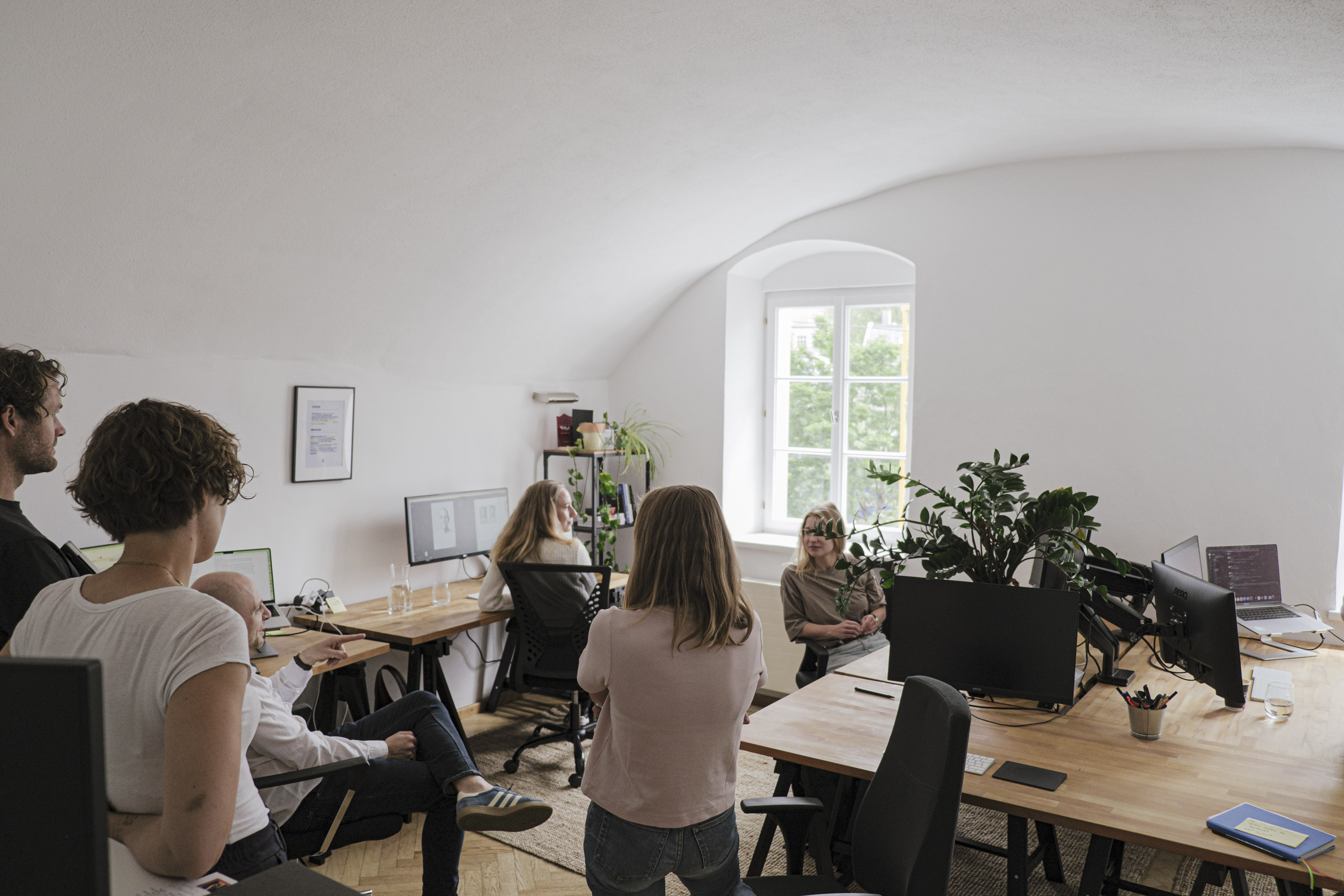 Team Empatic bei einer Besprechung im Büro mit Dachgewölbe