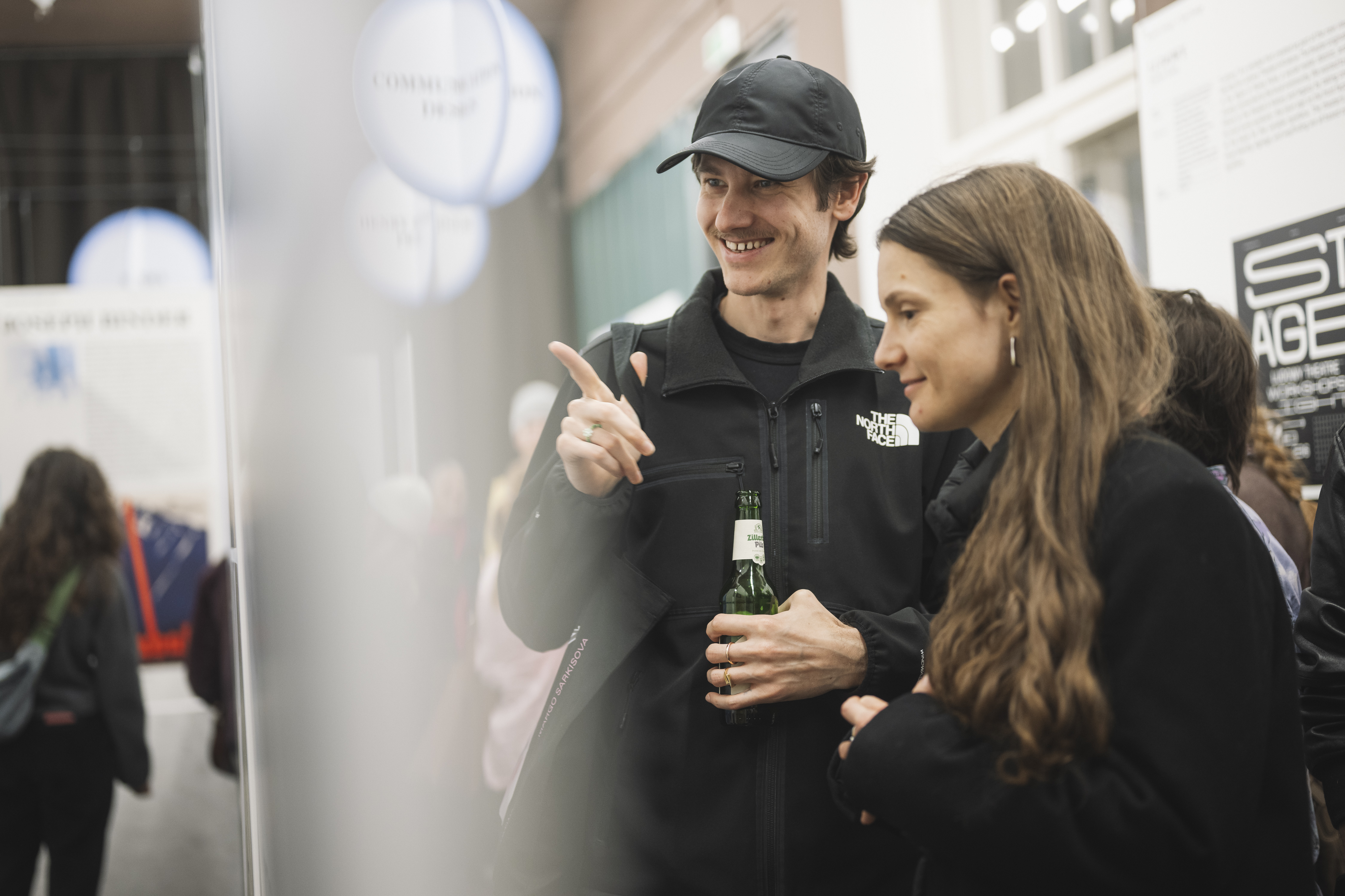 zwei Besucher:innen vor Plakaten