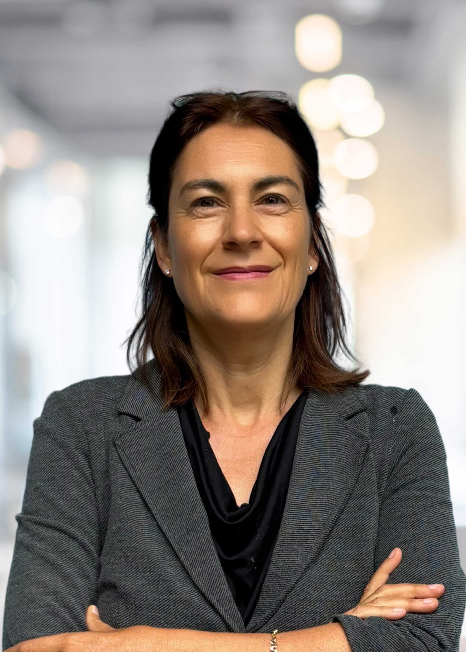 Portr&auml;t Tanja Sattele, braune halblange Haare, Brille ins Haar gesteckt, graues Jackett